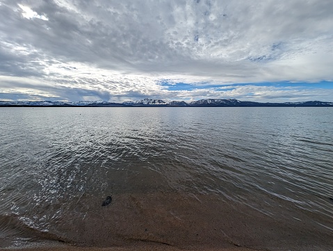 Longshot across a calm lake on a cloudy day.