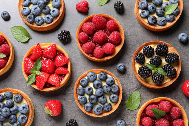 istock Tartlets with different fresh berries on grey table, flat lay. Delicious dessert 1935467161
