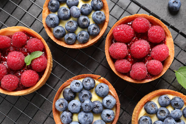 istock Tartlets with different fresh berries on grey table, flat lay. Delicious dessert 1935467701