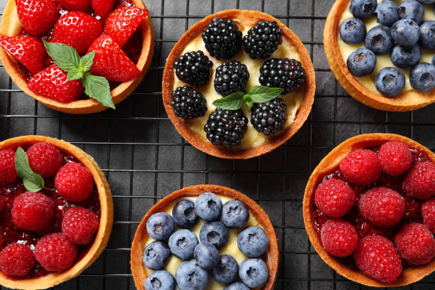 istock Tartlets with different fresh berries on grey table, flat lay. Delicious dessert 1935468207