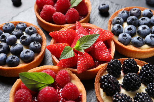 istock Tartlets with different fresh berries on slate plate, closeup. Delicious dessert 1935471384
