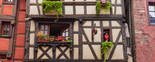 Decorated facade of half-timbered house in picturesque little town Riquewihr along Alsace Wine Route in eastern France.