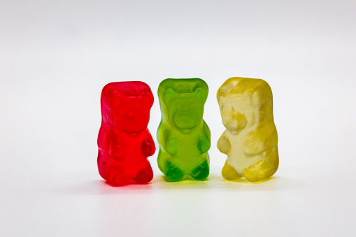 Three yummy gummy bears standing side by side.