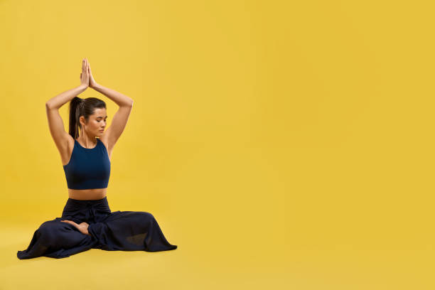 istock Attractive girl raising hands up with namaste gesture in studio. 1935495364