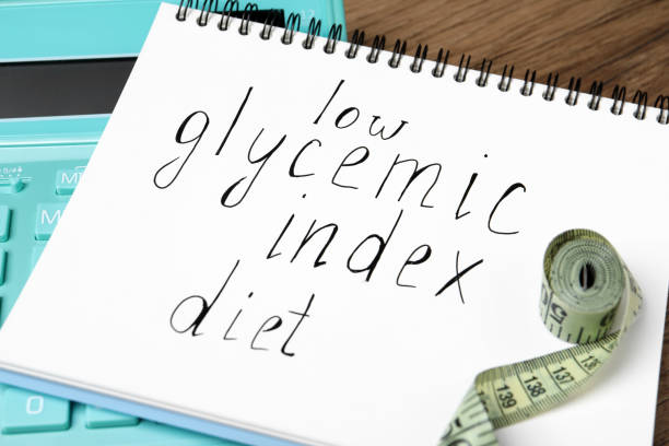 istock Notebook with words Low Glycemic Index Diet, measuring tape and calculator on table, closeup 1935498537