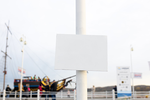 The big metal white board on port background, Empty signboard, nameplate with a space for your text. Horizontal banner.