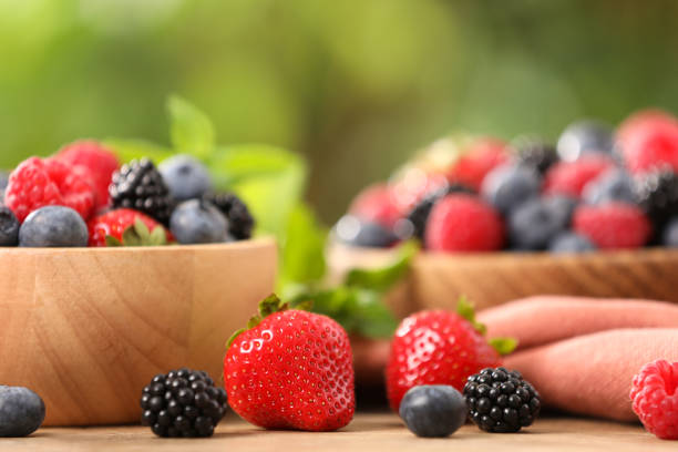 istock Bowls with different fresh ripe berries and mint on table outdoors, closeup 1935511899