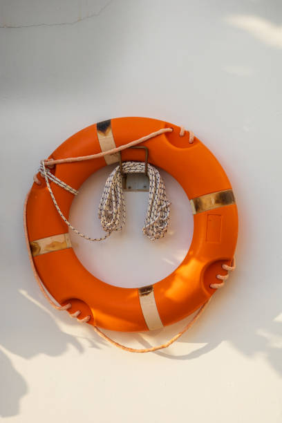 An orange lifebuoy is hanging on the wall