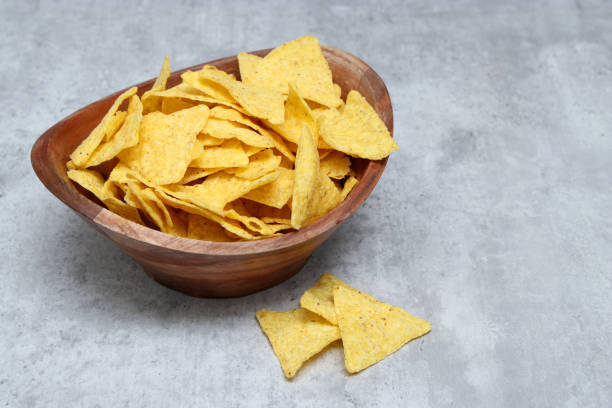 istock Salted tortilla in a wooden bowl, grey marble table with copy space 1935541407
