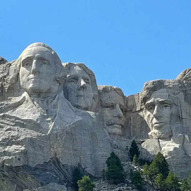 Mount Rushmore National Memorial is a sculpture in the Black Hills of South Dakota that features the faces of four US presidents carved into granite. The 60-foot-tall heads of George Washington, Thomas Jefferson, Theodore Roosevelt, and Abraham Lincoln represent the country's birth, growth, development, and preservation.