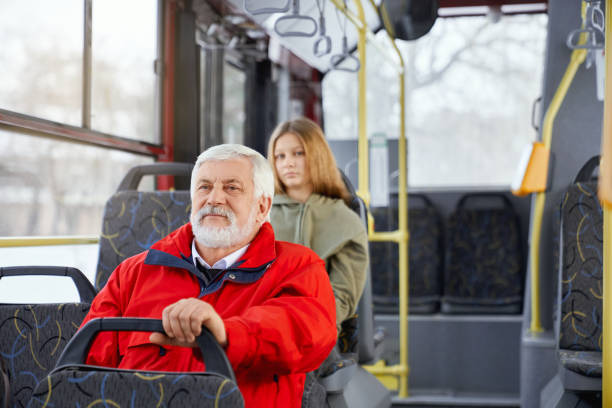 istock Old bearded man and blur girl behind sitting while travelling in modern bus. 1935558666