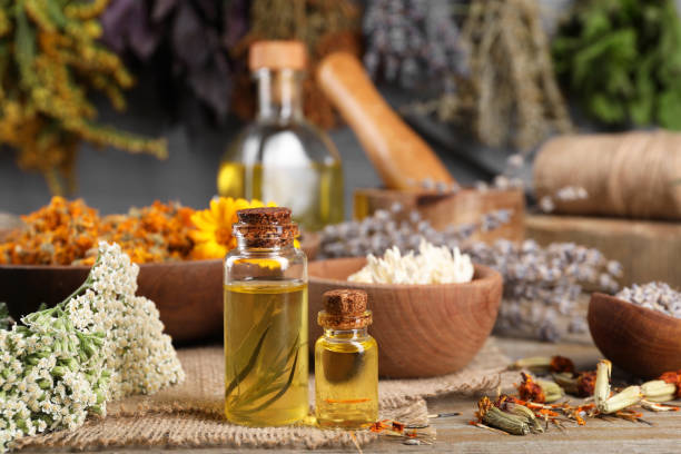 istock Bottles of essential oils and different herbs on wooden table 1935568655