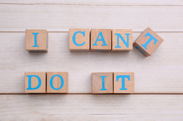 istock Motivation concept. Changing phrase from I Can't Do It into I Can Do It by removing cube with letter T on light wooden table, flat lay 1935590811