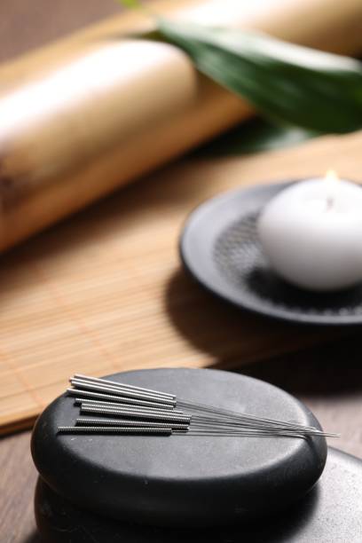 istock Stones with acupuncture needles on wooden table 1935608526