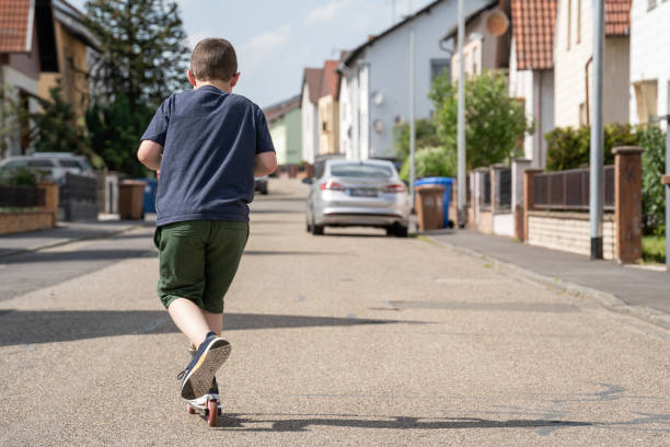 9 Year old boy rides a scooter on the street
