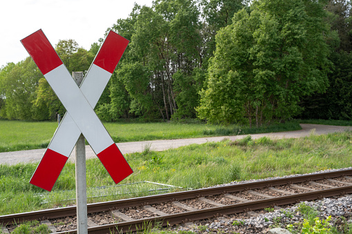 Railroad crossing with a st. andrew cross in the landscape in summer