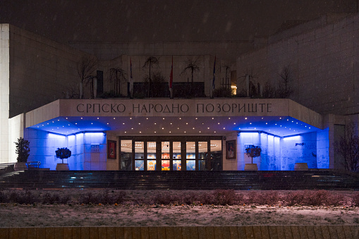 Novi Sad, Serbia. January - 15. 2024.  Night view of modern building of the Serbian National Theater is located in the old center of Novi Sad on snowy winter day with snowfall. Editorial image