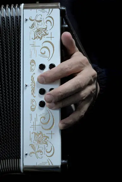Photo of left hand on a two-row accordion