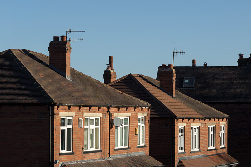 Row of four brick semi-detached suburban houses in the UK.
