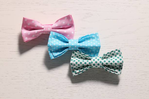 istock Stylish color bow ties on white wooden table, flat lay 1935644943