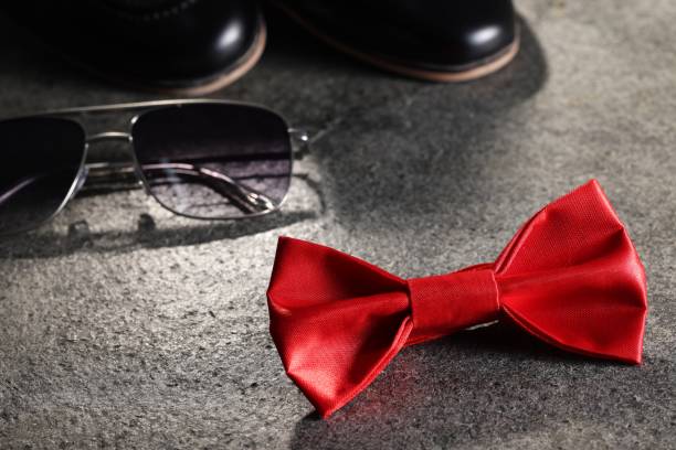 istock Stylish red bow tie and sunglasses on gray textured background 1935644962