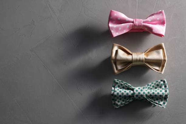 istock Stylish color bow ties on gray textured background, flat lay. Space for text 1935644978
