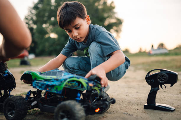 istock Boy putting back the shell on a remote controlled race car toy 1935645352