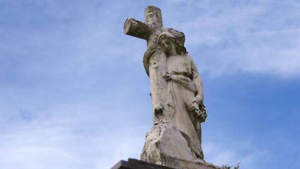 istock sculptural representation of angel hugging a cross 1935645445
