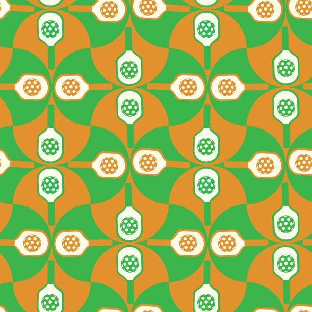 istock Pickleball paddles on green and orange scallop shapes seamless pattern. 1935652272