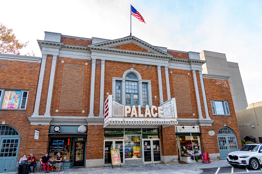 Palace Theatre in Lake Placid Town, Mirror Lake, Lake Placid, New York State, USA.  There are people in a boat out on the lake.