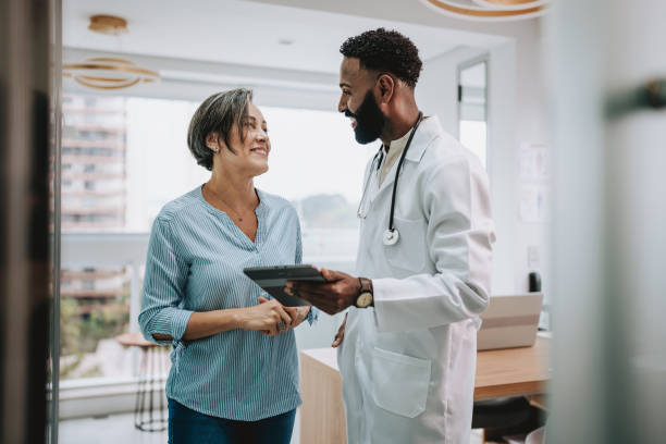 istock Doctor talking to patient holding digital tablet 1935661291