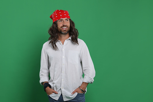 Stylish hippie man on green background, space for text