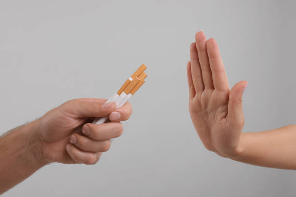 istock Stop smoking concept. Woman refusing cigarettes on grey background, closeup 1935710166