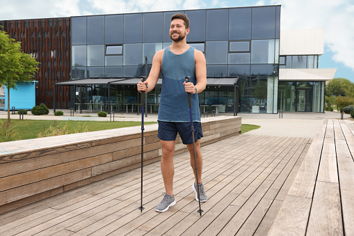 Man practicing Nordic walking with poles outdoors