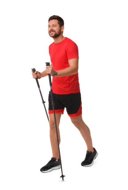 istock Man practicing Nordic walking with poles isolated on white 1935727261