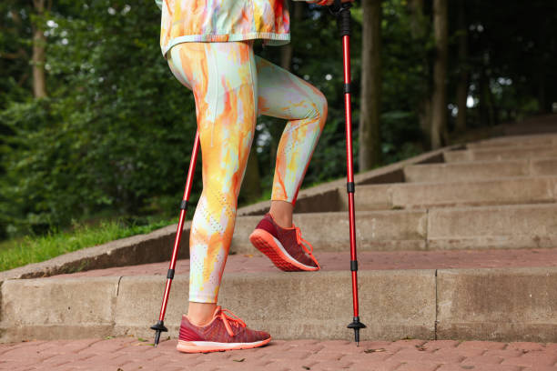 istock Young woman practicing Nordic walking with poles on steps outdoors, closeup 1935728850