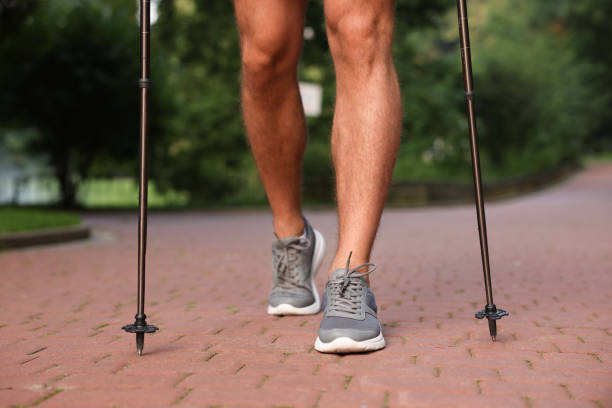 istock Man practicing Nordic walking with poles outdoors, closeup 1935729369