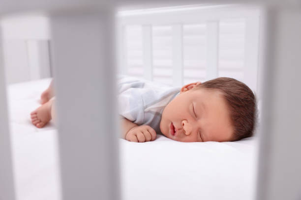 istock Cute newborn baby sleeping in crib. Bedtime 1935734064