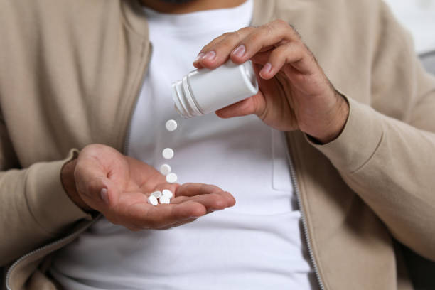 istock Man pouring antidepressants from bottle onto hand, closeup view 1935746530