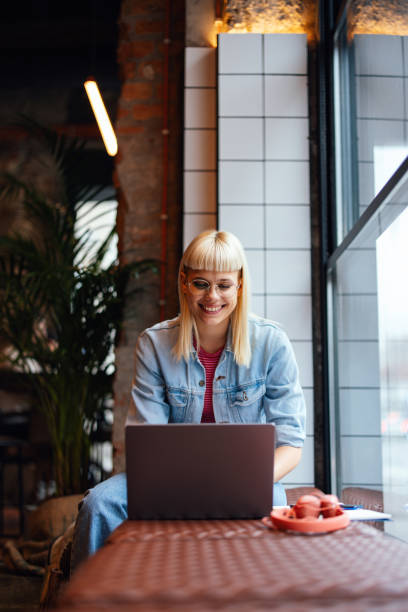 istock Portrait of a Beautiful Female Student Using Laptop Computer in the Cafeteria 1935765346