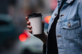Close Up of an Anonymous Woman Walking and Holding a Paper Coffee Cup