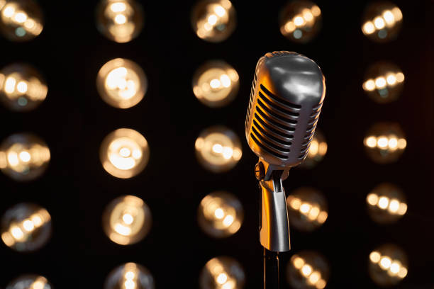 istock Classic vintage mic in front of blurred spotlights on black background. 1935797894