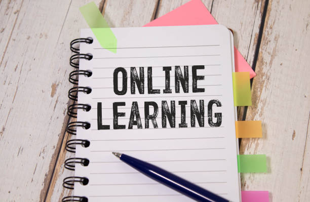 istock Open laptop with isolated white screen on old wooden desk with text ONLINE LEARNING. 1935809273