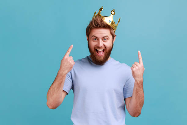 istock Man points fingers on golden crown on head, showing her leadership qualities, concept of authority. 1935828084
