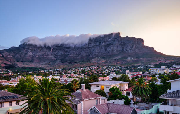 Table Mountain peak covered with cloud and suburb nestled on the foothills of Table Mountainat during sunset, Cape Town, South Africa Table Mountain peak covered with cloud and suburb nestled on the foothills of Table Mountainat during sunset, Cape Town, South Africa table mountain and the tablecloth stock pictures, royalty-free photos & images