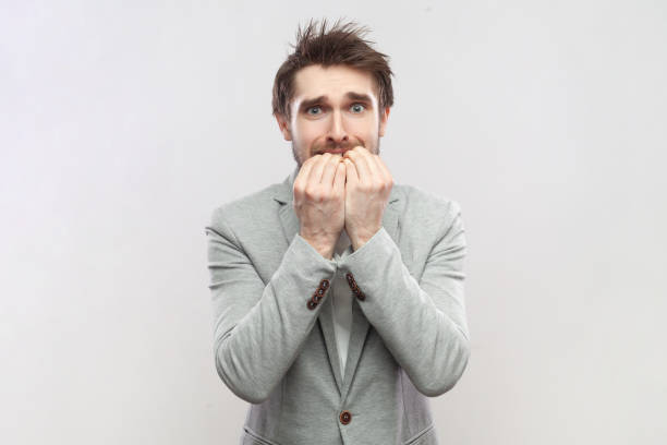 istock Nervous worried man biting his fingernails, looking at camera, having problems, looks scared. 1935874731