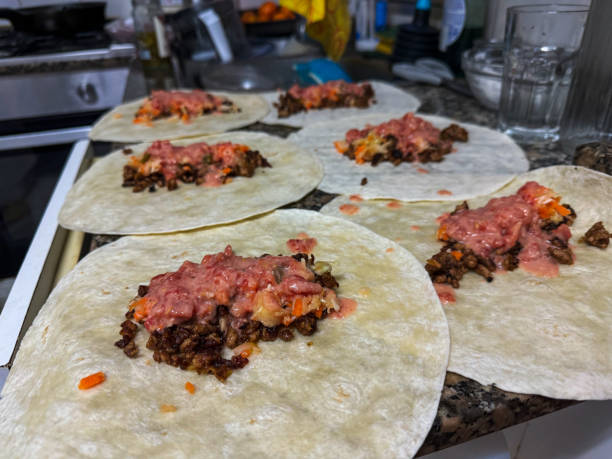 istock Culinary Craft in Progress: The Art of Assembling Authentic Homemade Tacos on a Bustling Kitchen Counter 1935990363