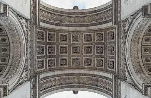 France, Paris - Jan 03, 2024 - Looking up at the centre of the famous Arc de Triomphe. Detail under view of carvings under the arch of the Triumphal Arch. Iconic touristic architectural landmark of Paris, Selective focus.