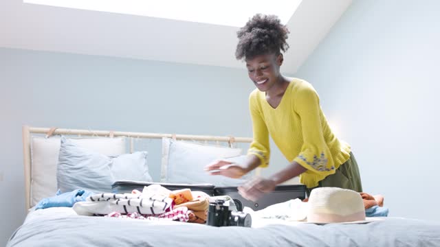 African American woman packing suitcase and preparing for travel