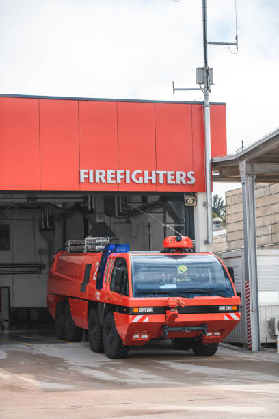 Firetrucks exiting airports fire department garage for an emergency at the airfield runway-